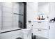 Modern bathroom showcasing a shower-tub combo with a black-framed glass door and a sleek white vanity at 2023 N 79Th Pl, Scottsdale, AZ 85257