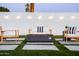 Inviting backyard scene features a modern fire pit surrounded by comfortable lounge seating and string lights at 2023 N 79Th Pl, Scottsdale, AZ 85257