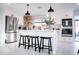Modern kitchen with white cabinets, stainless steel appliances, and island with barstool seating and decorative tile backsplash at 2023 N 79Th Pl, Scottsdale, AZ 85257