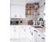 Stylish kitchen with white cabinetry, a mosaic backsplash, and open shelves with decorative accents at 2023 N 79Th Pl, Scottsdale, AZ 85257