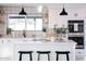 Well-lit kitchen with a stylish backsplash, stainless steel appliances, and an island with barstool seating at 2023 N 79Th Pl, Scottsdale, AZ 85257
