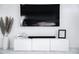 Stylish living room featuring a large TV, sound bar, modern white cabinet, and decorative vase with tall grass at 2023 N 79Th Pl, Scottsdale, AZ 85257