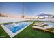 Stunning backyard pool area with modern lounge chairs, artificial grass, and a fun unicorn float at 2023 N 79Th Pl, Scottsdale, AZ 85257
