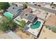 This home offers an aerial view of pool, solar panels, lush greenery, and backyard patio at 207 E Strahan Dr, Tempe, AZ 85283