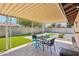 Backyard featuring a covered patio, artificial grass, patio table set, and rock landscaping at 207 E Strahan Dr, Tempe, AZ 85283