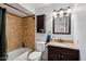 Bathroom features a shower-tub combo with tiled walls and a vanity with a granite countertop at 207 E Strahan Dr, Tempe, AZ 85283