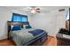 Cozy bedroom features hardwood floors, ceiling fan, blue curtains, and a comfortable bed at 207 E Strahan Dr, Tempe, AZ 85283
