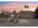 Charming single-story home featuring desert landscaping, a two-car garage, and solar panels for energy efficiency at 207 E Strahan Dr, Tempe, AZ 85283