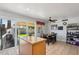Bright kitchen with tile flooring, sliding glass doors to the backyard, and an island with granite countertops at 207 E Strahan Dr, Tempe, AZ 85283