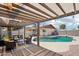 Backyard featuring a shaded patio, swimming pool, and well manicured backyard at 207 E Strahan Dr, Tempe, AZ 85283