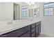 Bathroom with double sink vanity with dark cabinets, large mirror and bright natural light at 22306 N 34Th Pl, Phoenix, AZ 85050