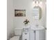 Well-lit powder room featuring a pedestal sink, oval mirror, and modern decor at 22306 N 34Th Pl, Phoenix, AZ 85050