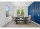 Elegant dining room features a modern chandelier and a blue accent wall with seating for six at 22306 N 34Th Pl, Phoenix, AZ 85050