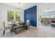 Dining room with designer lighting, a modern accent wall, and views into the living area at 22306 N 34Th Pl, Phoenix, AZ 85050