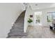 Bright foyer with gray wood-look flooring and stairs leading to the upper level, showcasing a welcoming entrance at 22306 N 34Th Pl, Phoenix, AZ 85050