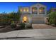 Elegant two-story home with arched windows, balcony, and a well-manicured front yard at twilight at 22306 N 34Th Pl, Phoenix, AZ 85050