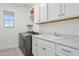 Bright laundry room features modern washer and dryer, white cabinetry, sink and attractive patterned flooring at 22306 N 34Th Pl, Phoenix, AZ 85050