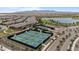 Community aerial view showcases tennis courts, a serene lake, lush greenery, and mountain views at 25030 N 172Nd Ln, Surprise, AZ 85387