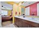 Elegant bathroom with double vanity, granite countertop, and a view of the primary bedroom at 25030 N 172Nd Ln, Surprise, AZ 85387