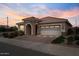 Charming single-story home featuring a two-car garage, and stone accents at the entrance, complemented by well-maintained landscaping at 25030 N 172Nd Ln, Surprise, AZ 85387