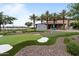 Putting green area showcasing the lake, palm trees, putting green area, and seating areas for residents at 25030 N 172Nd Ln, Surprise, AZ 85387