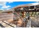 Open front porch with a brick floor, wood beams, potted cacti, and two chairs, creating an inviting entrance at 25232 N Horseshoe Trl, Scottsdale, AZ 85255