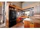 This kitchen has a black refrigerator, wooden cabinetry and a nook for eating at 25232 N Horseshoe Trl, Scottsdale, AZ 85255