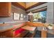 This kitchen nook features wooden furniture, brick floors and interesting architecture at 25232 N Horseshoe Trl, Scottsdale, AZ 85255
