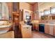This eat-in kitchen features wooden cabinetry, brick floors, and modern appliances at 25232 N Horseshoe Trl, Scottsdale, AZ 85255