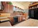 This eat-in kitchen offers wooden cabinetry and sleek black appliances with lots of natural light at 25232 N Horseshoe Trl, Scottsdale, AZ 85255