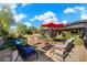 Enjoy an outdoor lounge area near the pool, shaded by a patio umbrella and surrounded by plants at 25232 N Horseshoe Trl, Scottsdale, AZ 85255
