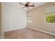 Bedroom featuring tile flooring, a ceiling fan, and a bright window letting in natural light at 27581 N 129Th Ln, Peoria, AZ 85383