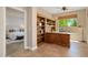 A bright home office features custom built-in wooden shelving and a large window providing natural light at 27581 N 129Th Ln, Peoria, AZ 85383