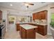 Expansive kitchen with granite counters, center island, wood cabinetry, and backyard views at 27581 N 129Th Ln, Peoria, AZ 85383