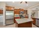 Bright kitchen features stainless steel appliances, wooden cabinets, tile flooring, and a central island at 27581 N 129Th Ln, Peoria, AZ 85383