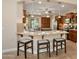 Open kitchen area featuring barstool seating, granite countertops and wood cabinetry at 27581 N 129Th Ln, Peoria, AZ 85383