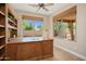 Bright office features a large desk, built-in bookshelves, and scenic backyard views at 27581 N 129Th Ln, Peoria, AZ 85383