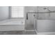 Bathroom with a soaking tub, glass-enclosed shower with modern fixtures, and neutral-toned tiling at 30639 N Dorado Ct, Queen Creek, AZ 85144