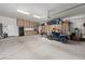 Spacious garage with ample storage cabinets and a black refrigerator and a blue off-road vehicle at 30639 N Dorado Ct, Queen Creek, AZ 85144
