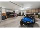 Large three car garage with built-in storage cabinets and an off-road vehicle at 30639 N Dorado Ct, Queen Creek, AZ 85144