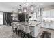 Spacious kitchen with white cabinetry, a gray island with seating, and modern pendant lighting at 30639 N Dorado Ct, Queen Creek, AZ 85144