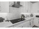 Modern kitchen showcases a sleek cooktop, stylish backsplash, white countertops and cabinetry with elegant hardware at 30639 N Dorado Ct, Queen Creek, AZ 85144