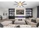Relaxing living room features a large television, custom shelving, an electric fireplace and a comfortable sectional sofa at 30639 N Dorado Ct, Queen Creek, AZ 85144