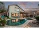 Landscaped backyard with a freeform pool, patio area, and mature trees offers a private oasis at 3466 E Bruce Ave, Gilbert, AZ 85234