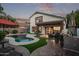 Exterior view of home and backyard with pool, outdoor kitchen, and covered patio at 3466 E Bruce Ave, Gilbert, AZ 85234