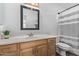 Bathroom features a single sink vanity, large mirror, and shower with a gray striped curtain at 3466 E Bruce Ave, Gilbert, AZ 85234