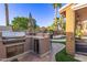 Well-equipped outdoor kitchen with a built-in grill, bar seating, and picturesque backyard view at 3466 E Bruce Ave, Gilbert, AZ 85234