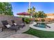 Relaxing pool area with lounge chairs, umbrella, and lush landscaping, creating a private oasis at 3466 E Bruce Ave, Gilbert, AZ 85234