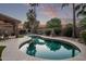 Enjoy this backyard pool with lush landscaping, outdoor seating and mature palm trees at 3466 E Bruce Ave, Gilbert, AZ 85234