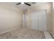 Carpeted bedroom features a ceiling fan, an adjacent room and double door closet at 3507 E Alfalfa Dr, Gilbert, AZ 85298